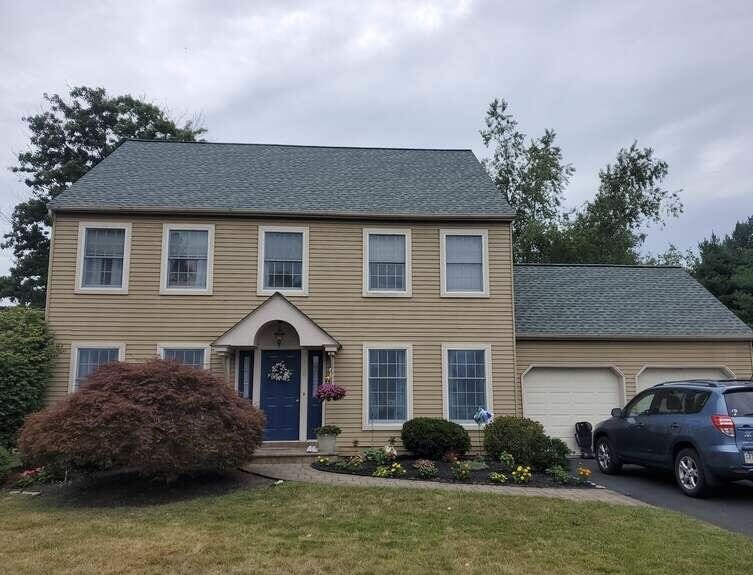 Chalfont, PA Before - We added the porch roof over the entire front of the house, and installed a standing seam metal roof over the porch, replaced the windows, replaced the vinyl siding with James Hardie Fiber Cement Siding, and installed new trim, soffits, and gutters.